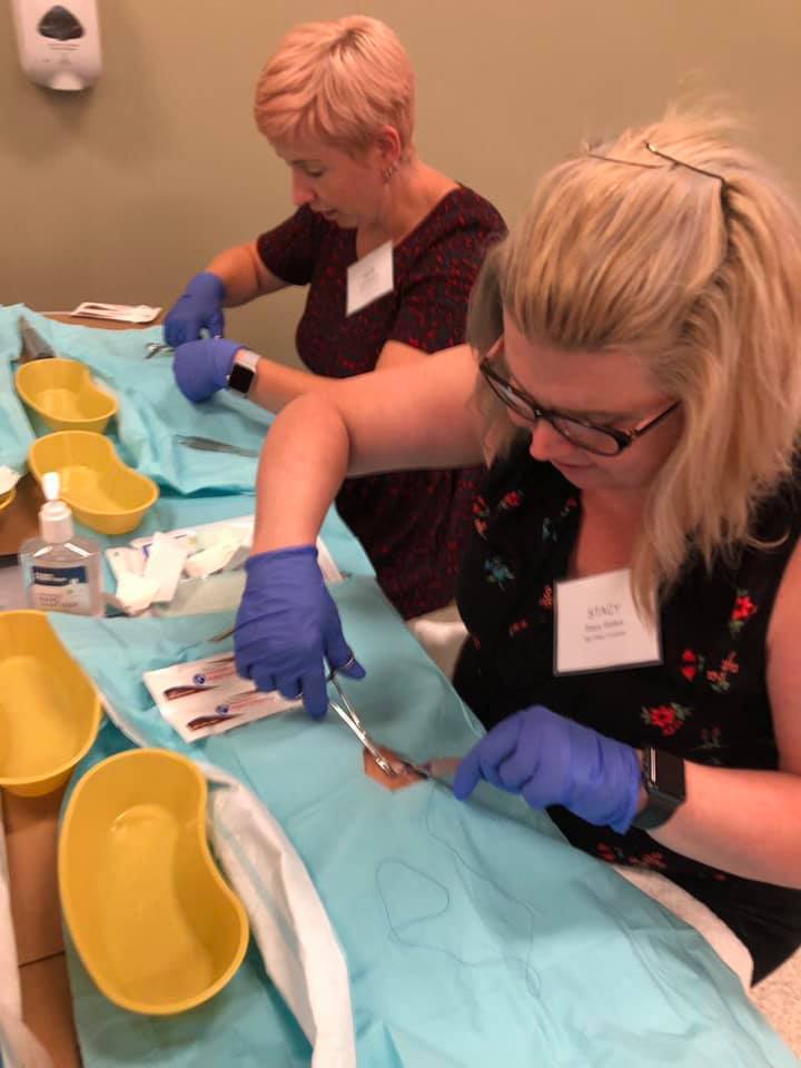 Founding members practice wound closure at the athletic training education colloquium.